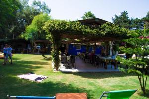 a garden with a pergola and tables and chairs at myndos bed & breakfast in Bodrum City