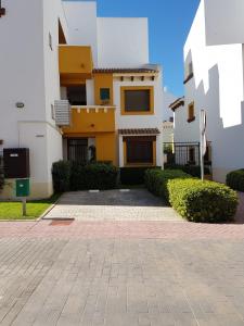 a yellow and white building with a courtyard at Costa Esuri in Ayamonte