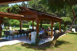 a wooden pavilion with tables and chairs in a park at myndos bed & breakfast in Bodrum City