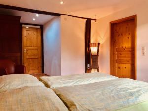 two beds in a bedroom with two doors at Ferienhaus "Ahle Schinn" in Bad Sooden-Allendorf