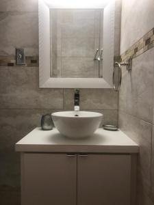 een badkamer met een witte wastafel en een spiegel bij Water Front Peaceful Apartment in San Juan