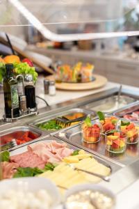 una línea de buffet con muchos tipos diferentes de comida en SeeLE Garda Hotel en Nago-Torbole