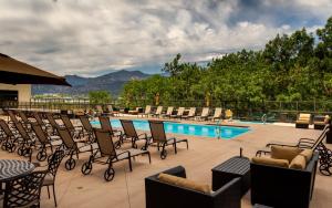 a patio area with chairs, tables and a pool at The Antlers, A Wyndham Hotel in Colorado Springs