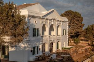 uma casa branca com mesas e cadeiras à sua frente em Menorca Experimental em Alaior