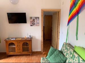 a living room with a couch and a tv on the wall at La Finca de Los Padres in Tefía