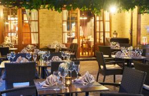 a restaurant with tables and chairs with glasses and napkins at DC Hotel & Restaurant Brussels South in Brussels