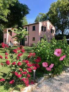 een roze huis met roze bloemen ervoor bij La Visciola - Country House del Conero in Sirolo