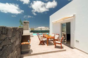 a patio with a table and chairs next to a wall at Villa Blue Horizon in Playa Blanca
