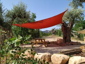a picnic table with a redarp hanging from a tree at Maset del Riu in Valderrobres