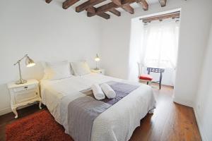 a white bedroom with a bed with two pillows on it at Rossio Hostel in Lisbon