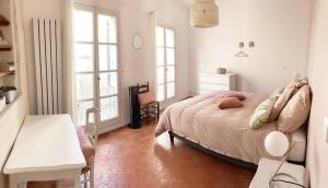 sypialnia z łóżkiem, stołem i oknami w obiekcie Arelate Séjour w mieście Arles