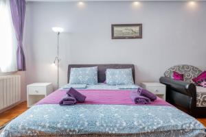 - une chambre avec un grand lit et une chaise dans l'établissement Apartment Gloria, à Belgrade
