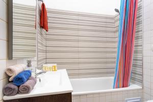 ein Badezimmer mit einem Waschbecken, einer Badewanne und einer Dusche in der Unterkunft LV Premier Apartments Baixa- CR in Lissabon