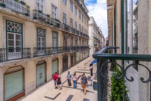 un grupo de personas caminando por una calle de la ciudad en LV Premier Apartments Baixa- CR, en Lisboa