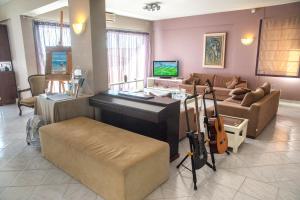 a living room with a piano and a couch at Mouikis Sun Village in Lakithra