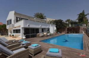 a large swimming pool in front of a house at Villa with heated pool and Jacuzzi Sea View 300m Front of the Beach in Eilat