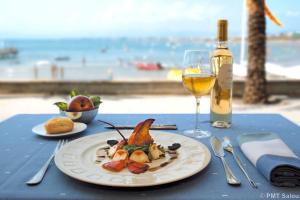 une table avec une assiette de nourriture et un verre de vin dans l'établissement Zeus Sant Jordi, à Salou