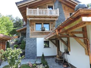 a house with a balcony on the side of it at Chalet L'Escapade in Charmey