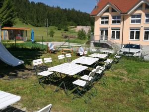 un grupo de mesas y sillas en un patio en Počitniška hiša Ostrnica, en Hrib-Loški Potok