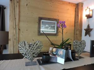 a table with some flowers and a picture on a wall at Chalet L'Escapade in Charmey