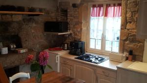 a kitchen with a stove top oven next to a window at Le four à pain in Sarcey