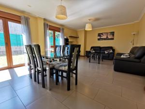 a dining room with a glass table and chairs at Casa Baixo O Castelo in Puente Caldelas