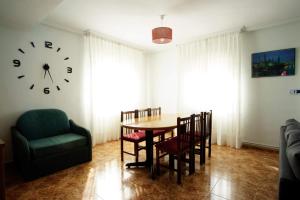 a dining room with a table and a clock on the wall at LA CASA DEL MONTE in Granja Llumes