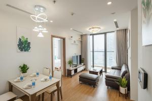 a living room with a table and chairs and a living room at Luxury Apartment Vinhomes Skylake in Hanoi