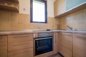 a kitchen with wooden cabinets and a sink and a window at SOA Village in Žabljak +39 photos