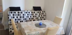 a table with a blue vase sitting on top of it at Mobile homes Olive and Sea in Bibinje