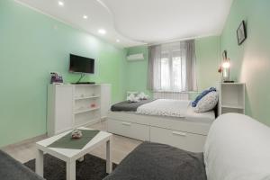 a small bedroom with a bed and a tv at Apartman Gloria 2 in Belgrade