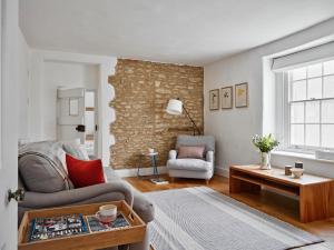 a living room with a couch and a table at Artisan Cottage in Chippenham