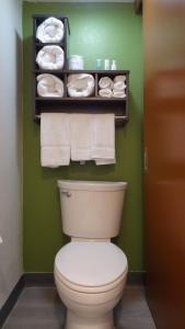 a bathroom with a toilet and towels on a green wall at Quality Inn & Suites Raleigh North in Raleigh +14 photos