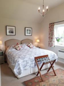 a bedroom with a bed and a table and a window at Wayside House B&B in Whichford