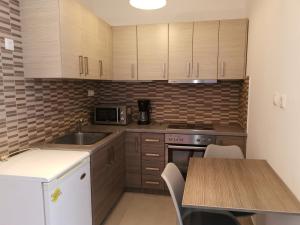 a kitchen with wooden cabinets and a sink and a table at Demirdesiou 127 Apartment in Athens