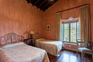 a bedroom with two beds and a window at El Tejar in Zufre