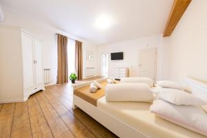 a large white bedroom with two beds and a television at Casa cu Nuc in Alba Iulia