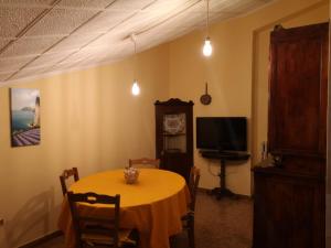 una sala da pranzo con un tavolo e una tv di LA CASA DEI RICORDI a Sirolo