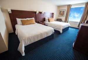 a hotel room with two beds and a desk at West Edmonton Mall Inn in Edmonton