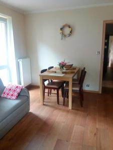 a dining room table and chairs in a living room at Apartament Marta in Polanica-Zdrój