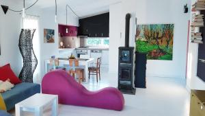 ein Wohnzimmer mit einem lila Sofa und einer Küche in der Unterkunft Country house in Banja Luka