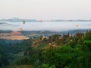 サン・カシャーノ・イン・ヴァル・ディ・ペーザにあるLe Massucceの谷上空を飛ぶ熱気球群