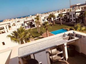 Vom Balkon eines Hotels genießen Sie Poolblick. in der Unterkunft Penthouse La Zenia in Playa Flamenca