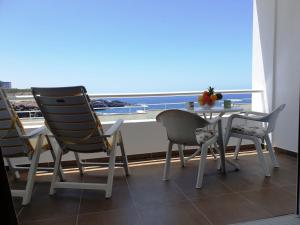 a table and chairs on a balcony with a view of the ocean at 100 meters from the ocean in Callao Salvaje