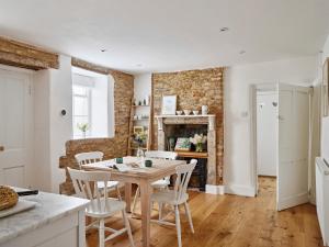 a kitchen and dining room with a table and chairs at Artisan Cottage - Historic cottage near to Bath, Lacock and Castle Coombe in Chippenham