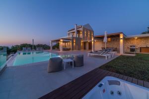 a house with a swimming pool and a building at Rethymno Villas in Prinés