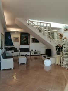 Il comprend un salon doté d'un mobilier blanc et d'un escalier. dans l'établissement Accussì, à Alcamo Marina