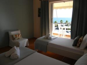 a hotel room with two beds and a view of the ocean at Villa Kostandin in Qeparo