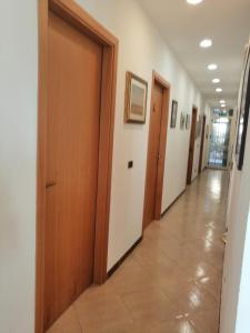 un couloir d'un hôpital avec des portes en bois et du carrelage dans l'établissement Accussì, à Alcamo Marina