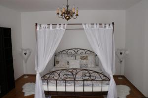 a bedroom with a bed with curtains and a chandelier at The Lakehouse Villa Neusiedl am See Wienerstraße 8 in Neusiedl am See